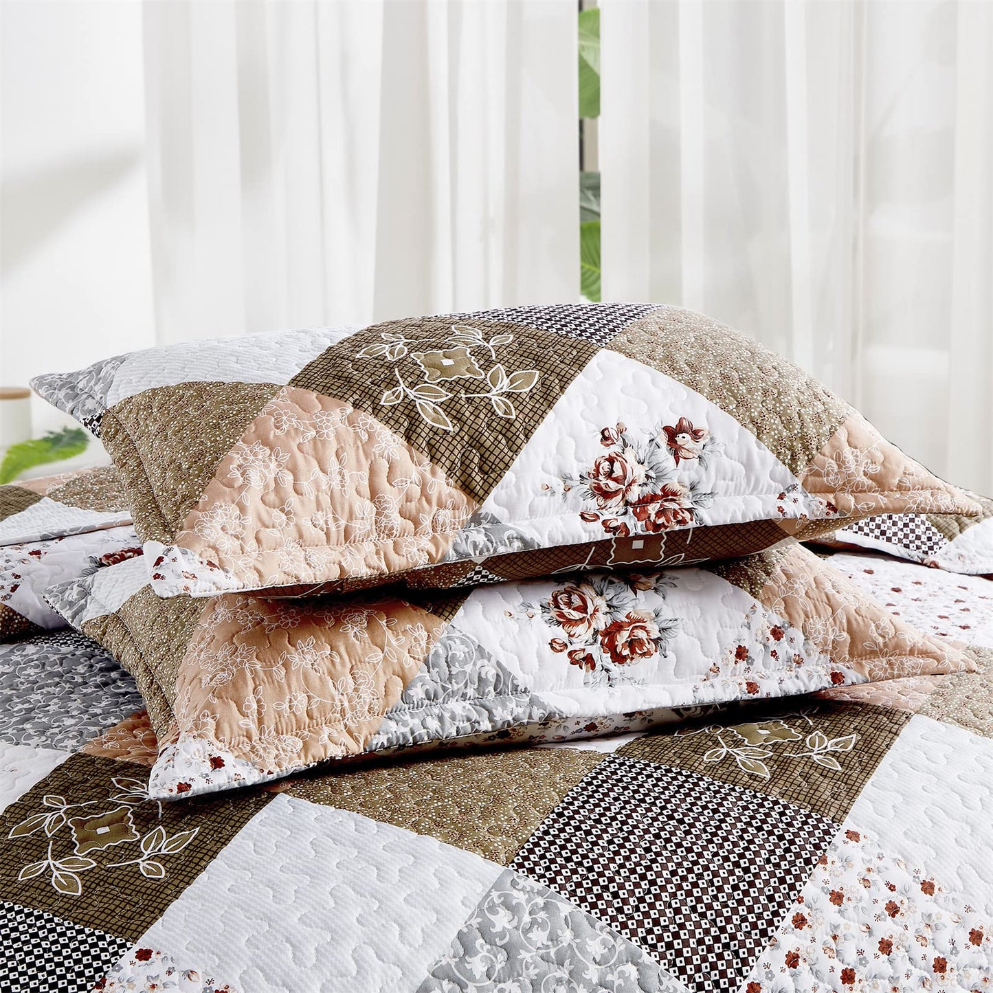Close-up of two matching pillowshams with floral patchwork pattern and scalloped edges from the Dinjoy Quilt Bedding Set