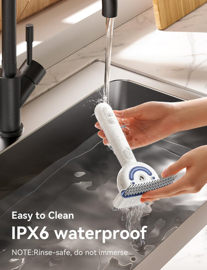 Close-up of hands rinsing the FEELNEEDY Dual-Sided Pet Steam Brush under a kitchen sink faucet, highlighting its IPX6 waterproof, rinse-safe design.