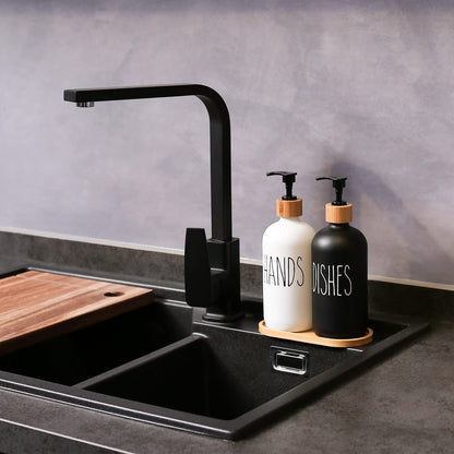 Modern kitchen sink with black faucet and cleaning supplies on a gray countertop.