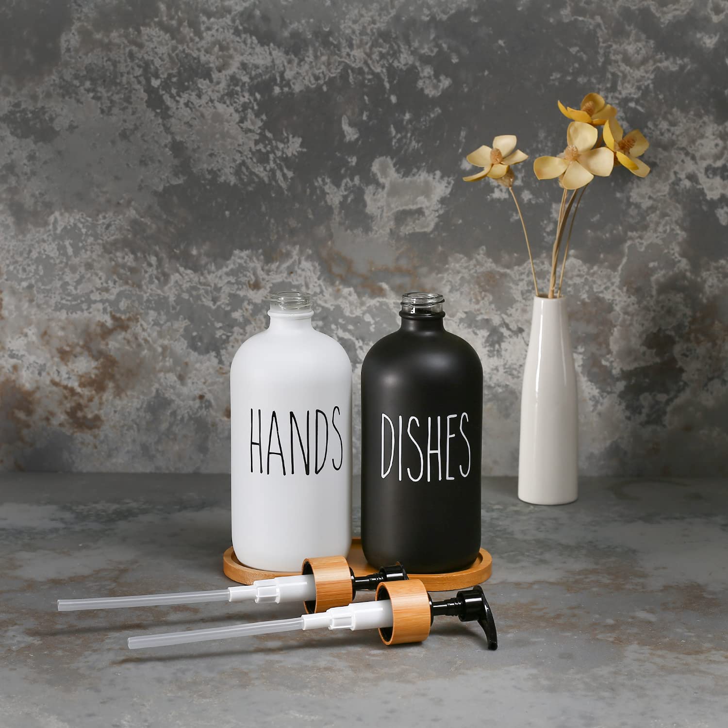 Hand and dish soap dispensers with a black and white design on a gray surface.