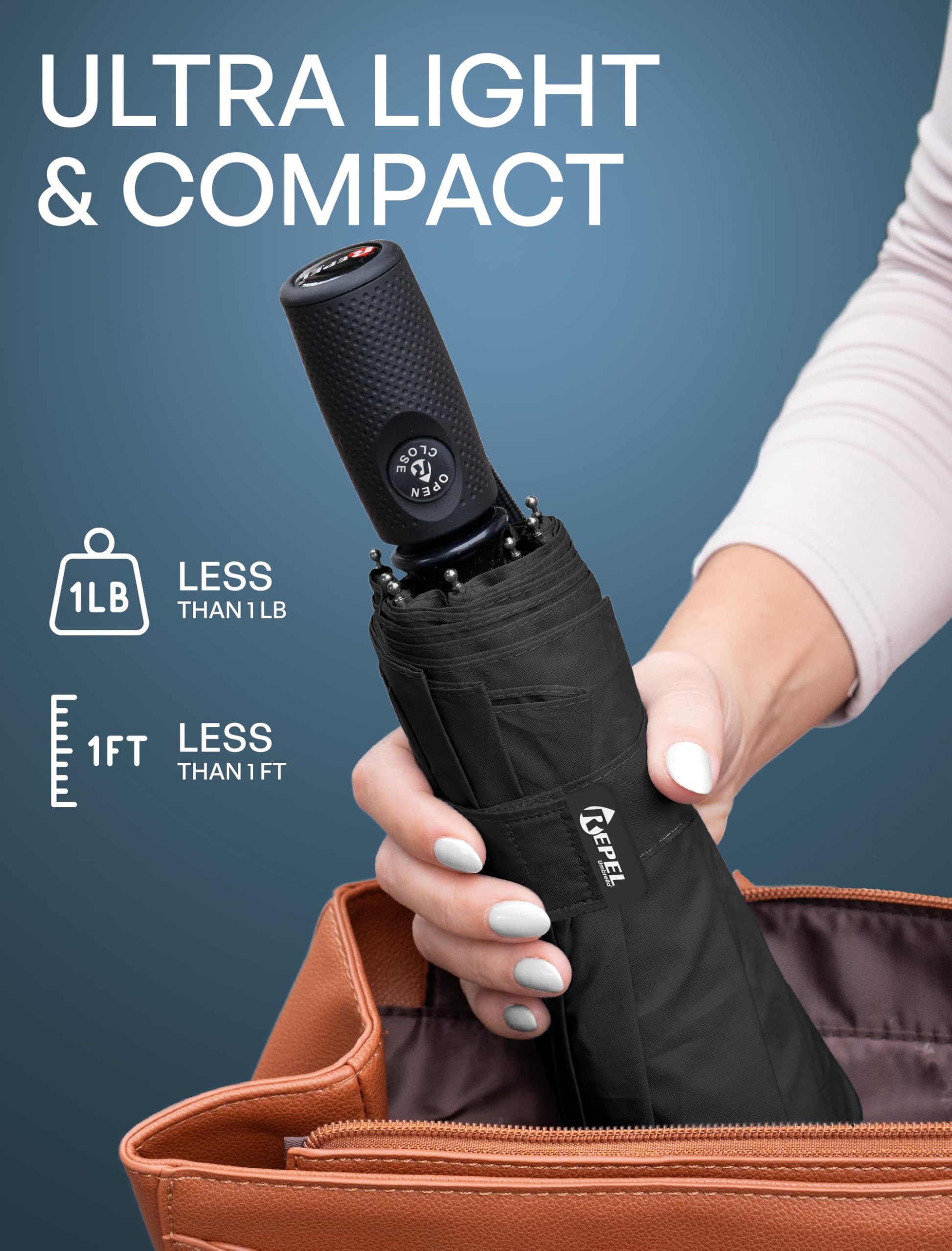 Hands holding a compact black folded Repel Windproof Travel Umbrella next to an open handbag, highlighting its lightweight and portable design.