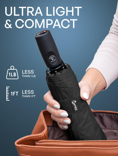Hands holding a compact black folded Repel Windproof Travel Umbrella next to an open handbag, highlighting its lightweight and portable design.