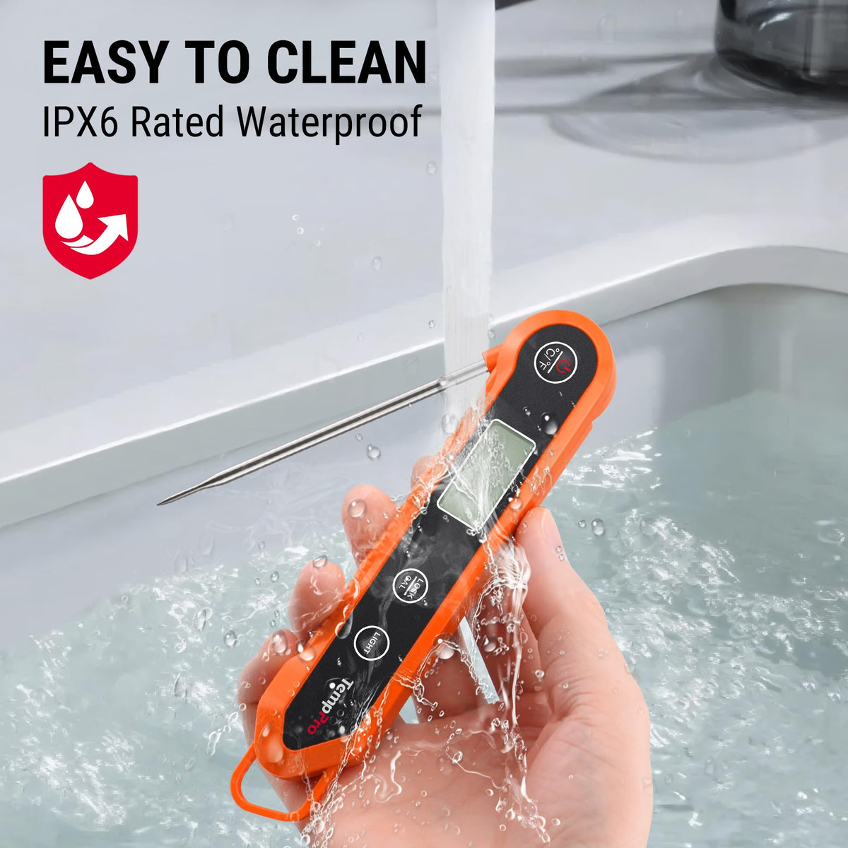 Orange TempPro digital meat thermometer being washed under running water to show its IPX6 waterproof feature