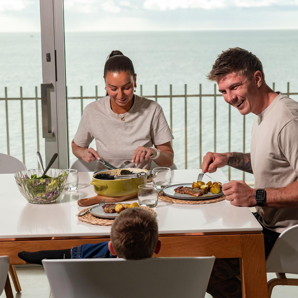 TrendPlain 470ml 2-in-1 glass olive oil dispenser placed on an outdoor balcony dining table while a couple enjoys a healthy meal
