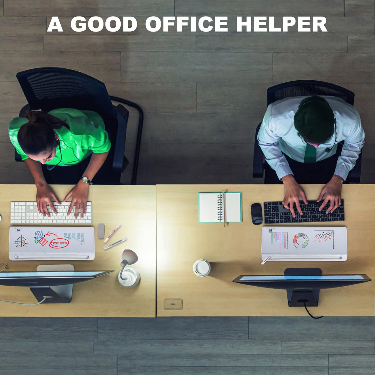 Overhead view of two people working at a desk with computers, office supplies, and the TSJ Office glass whiteboard labeled A Good Office Helper