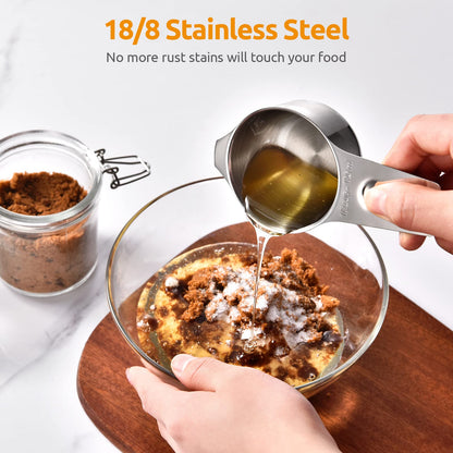 Stainless steel measuring cup being used to pour liquid into a dish with food, on a white background.