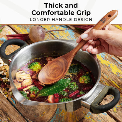 Close-up of a hand holding a long-handled Woodenhouse teak wood spoon lifting vegetables from a full soup pot, with 'Thick and Comfortable Grip' text visible.